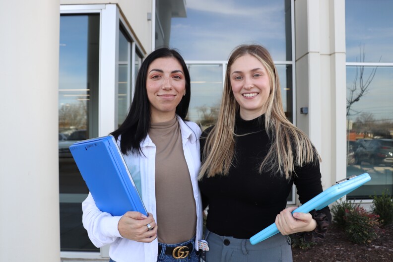 Rachel Wimp (left) and Clara Anderson pose for a photo in front of the Family & Children Services’ call center. The two regularly respond to mental health crisis calls for the 988 hotline.